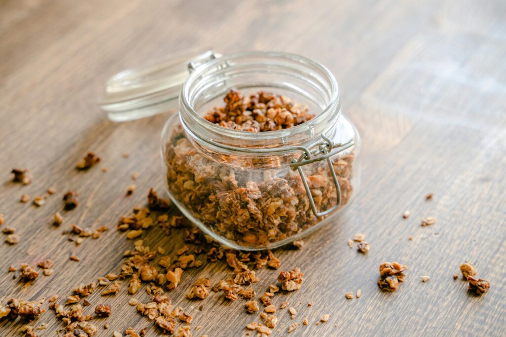 Homemade granola spilling from a glass jar, perfect snack idea.