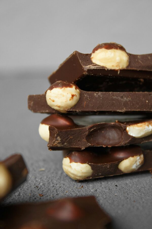 Stack of chocolate slices with embedded nuts in a close-up, showing texture and detail.