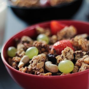 food-fruits-cereals-breakfast-3672 A vibrant red bowl of muesli with fresh fruits and nuts, perfect for a healthy breakfast.